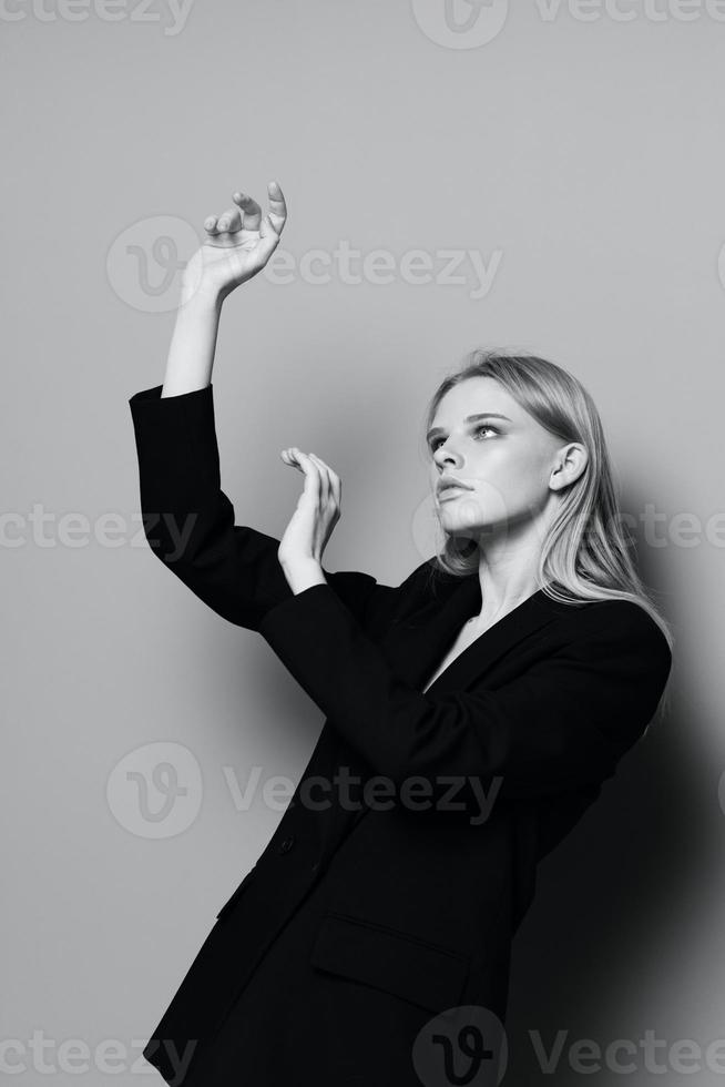 mode modèle fille posant avec sa mains en haut dans le studio dans noir et blanc style dans une classique veste photo