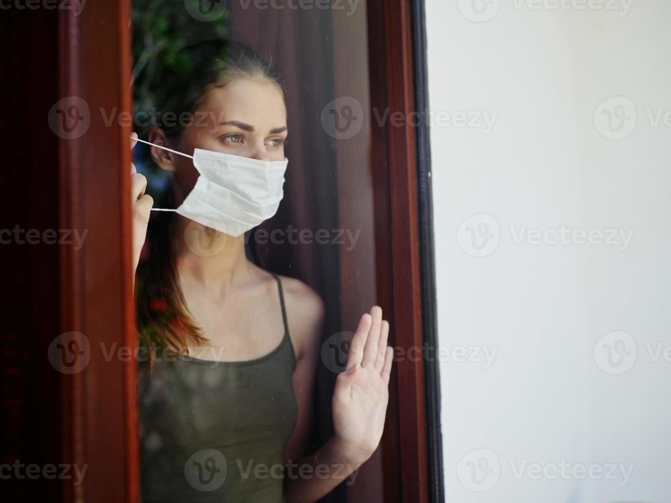 masqué femme à la recherche en dehors le fenêtre verrouillage interdire photo