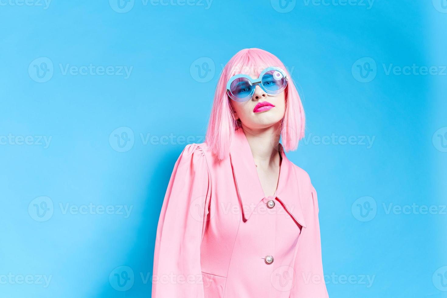 femme dans rose perruque et robe sur bleu Contexte photo