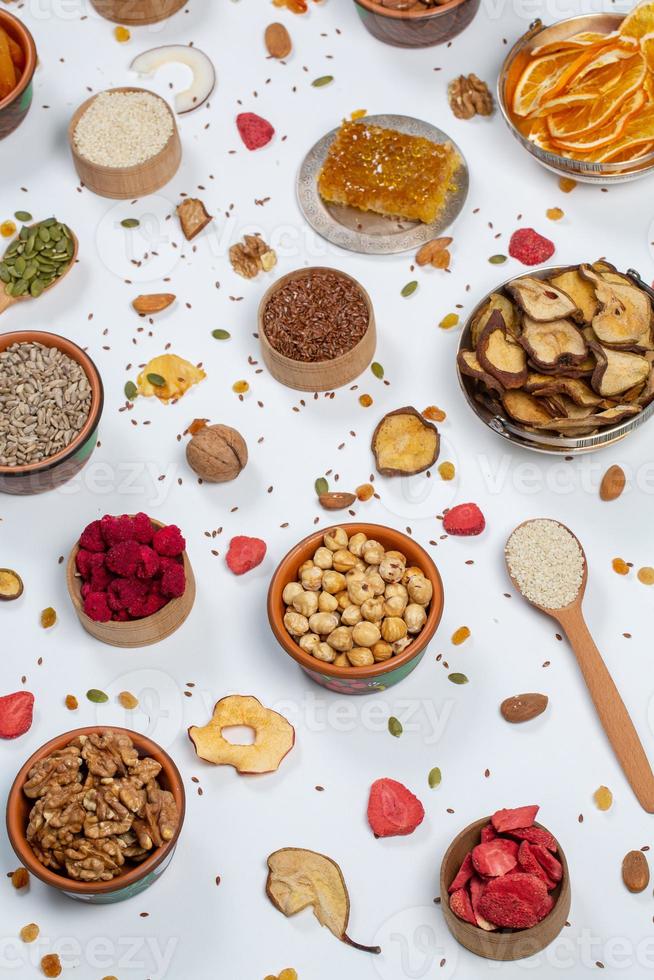 en bonne santé végétarien nourriture concept. assortiment de séché des fruits, des noisettes et des graines sur blanc Contexte. Haut voir. photo