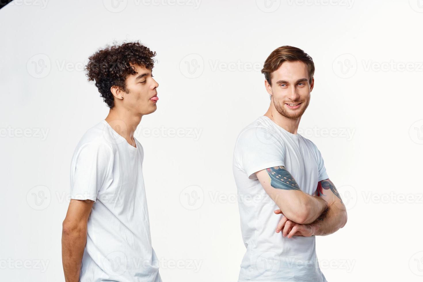 deux de bonne humeur copains dans blanc t-shirts supporter côté par côté tondu vue photo