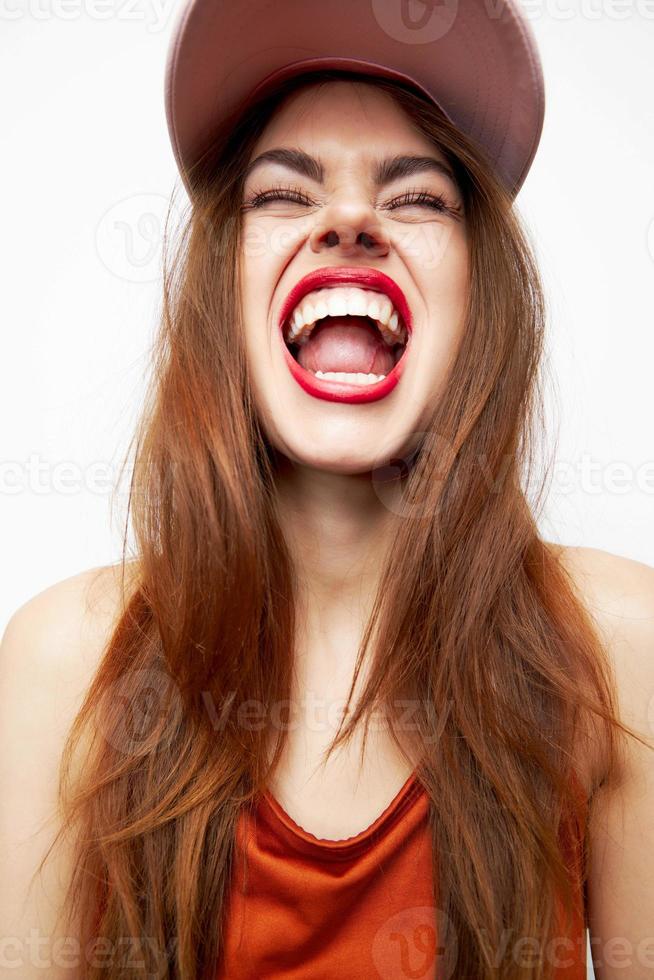 femme avec une casquette amusement gros sourire fermé yeux sur sa tête rouge lèvres photo