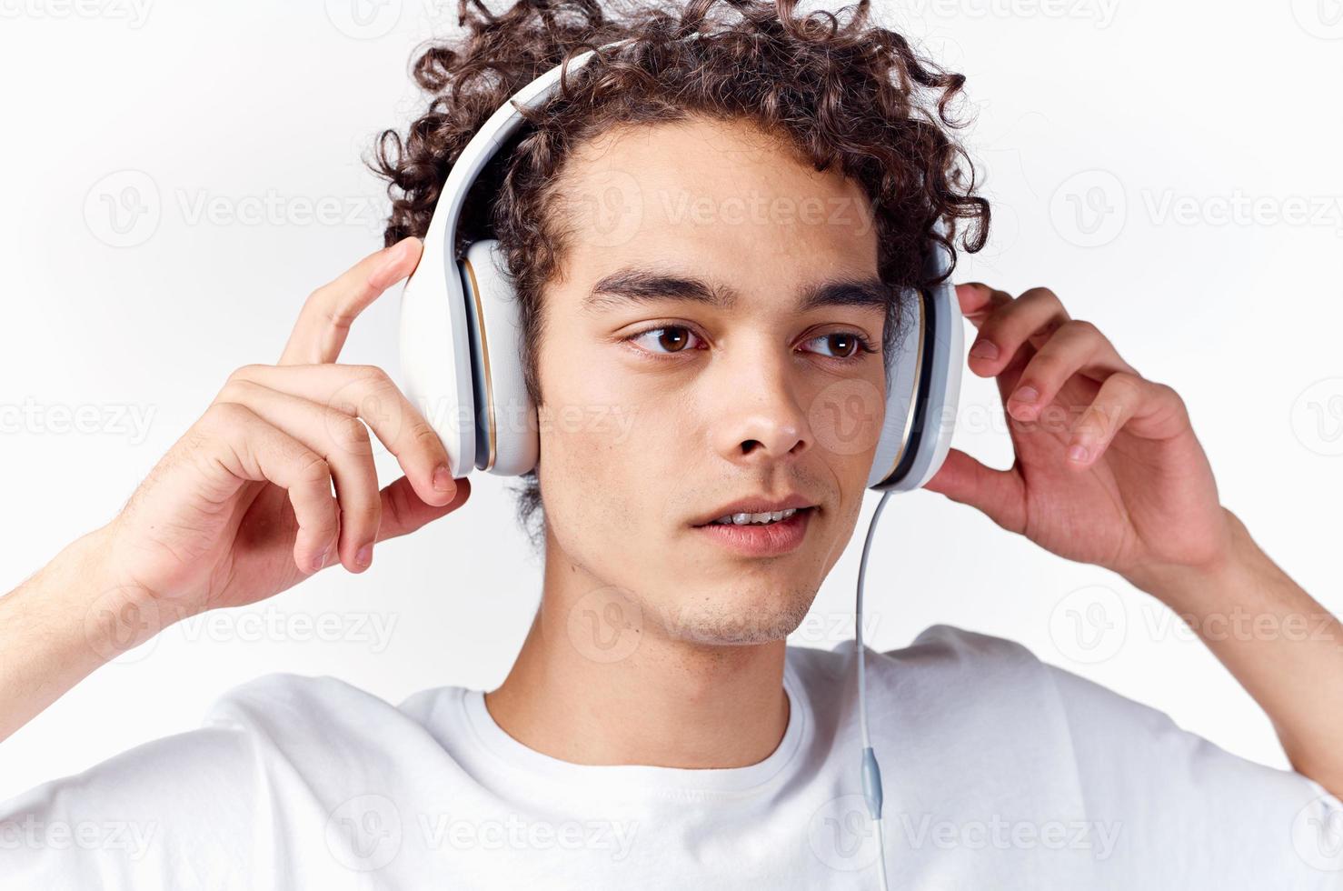 homme avec frisé cheveux et dans écouteurs écoute à la musique photo