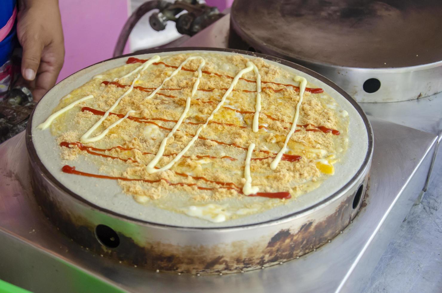 cuisine crêpe dessert avec Garniture, œuf, séché déchiqueté porc, ketchup, Mayonnaise dans rue nourriture marché Thaïlande. photo