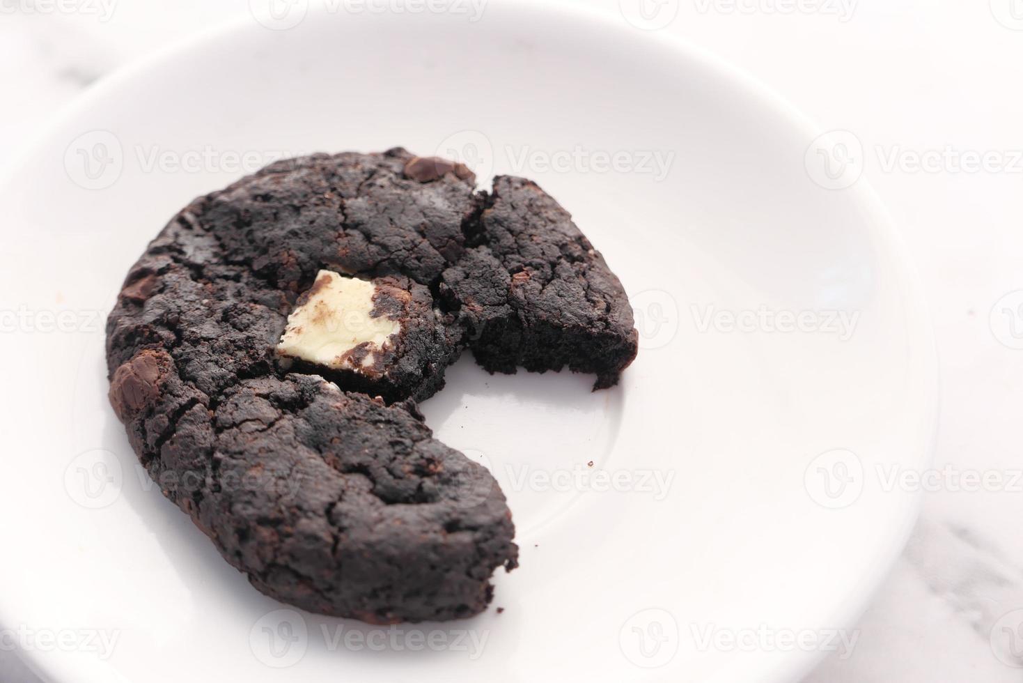 Biscuit au chocolat à moitié mangé sur une assiette photo