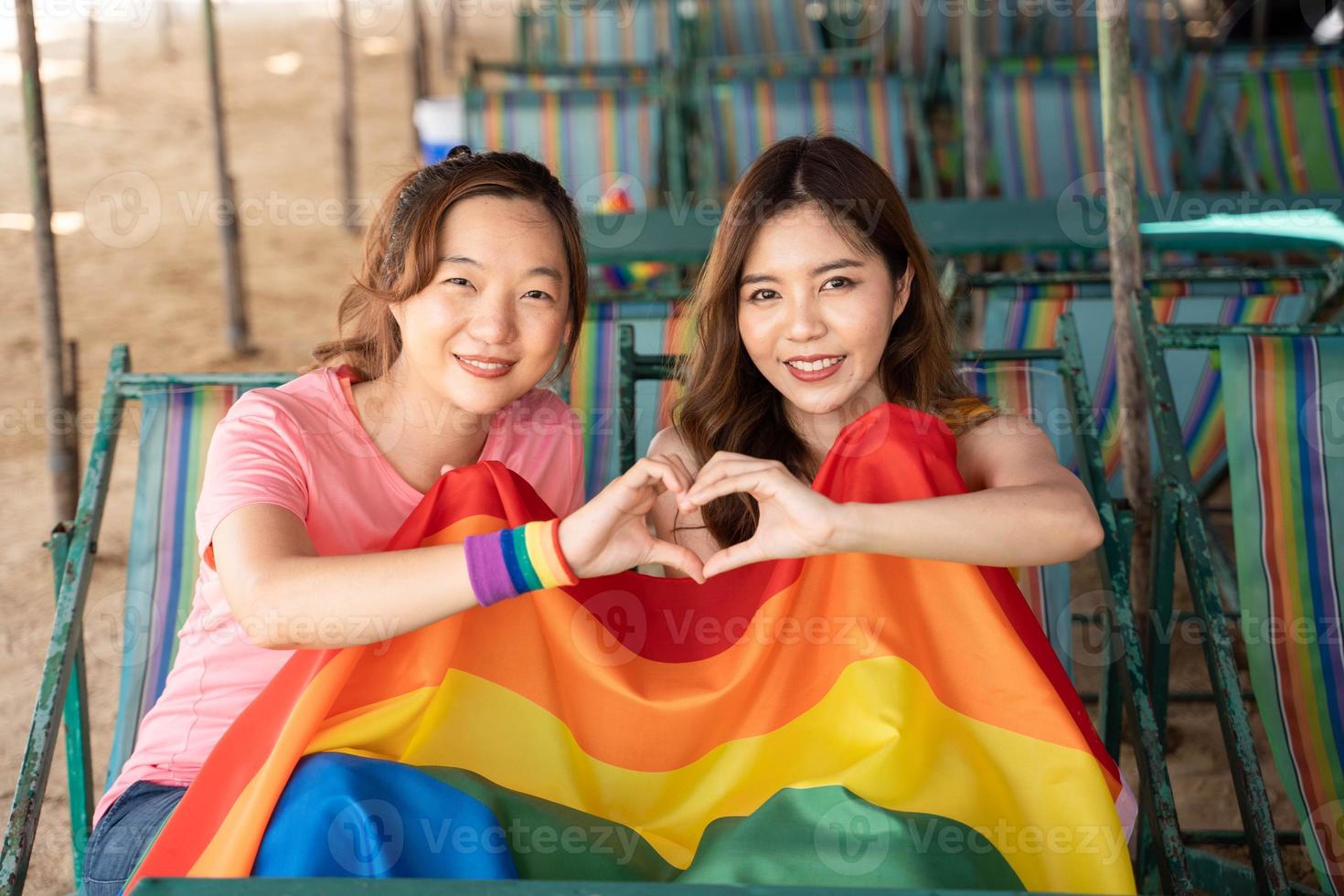 lesbienne femme avec gay fierté arc en ciel drapeau fabrication une cœur forme, une symbole de le lgbt communauté, égal droits, beauté et l'amour photo