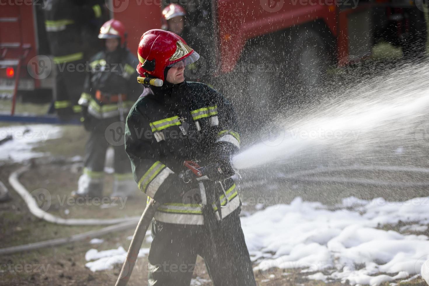 sapeurs pompiers éteindre une Feu. une équipe de sapeurs pompiers sur une Contexte de fumée et une Feu moteur photo