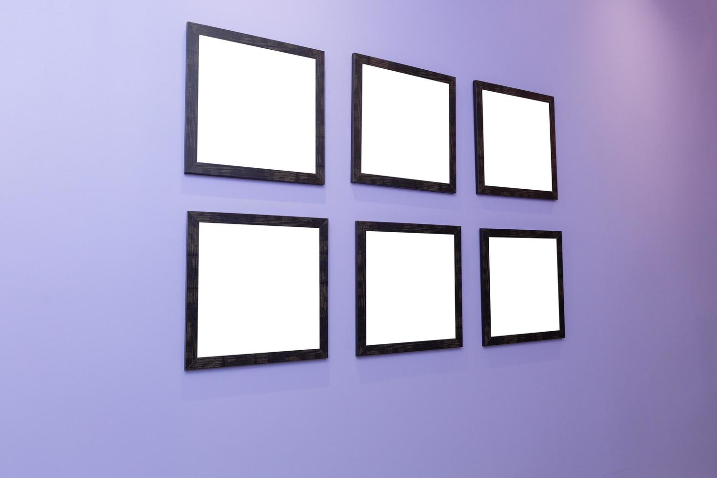 quatre noir cadres sur une violet mur avec une blanc Contexte. photo