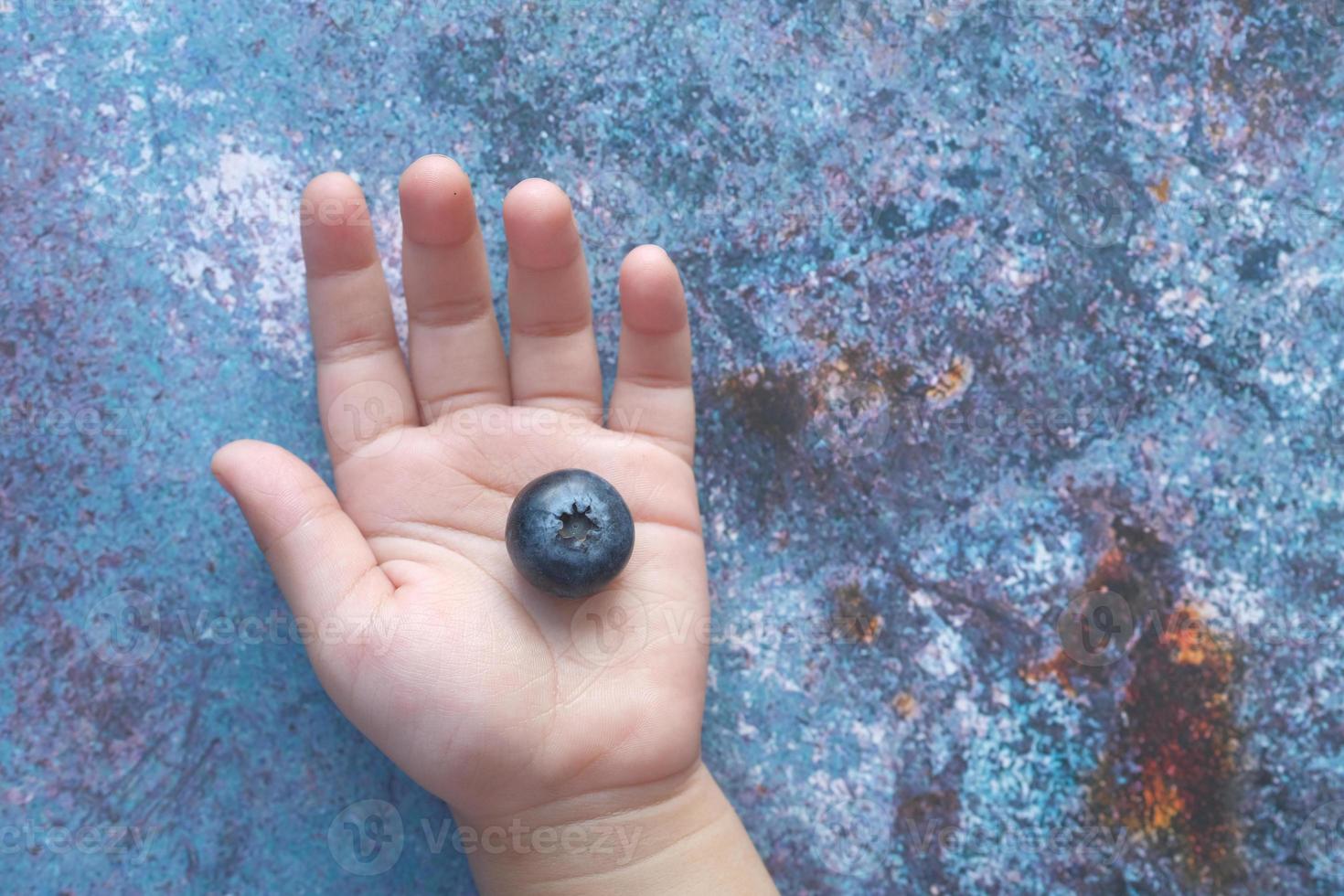 gros plan de baies bleues fraîches dans la main de l'enfant photo