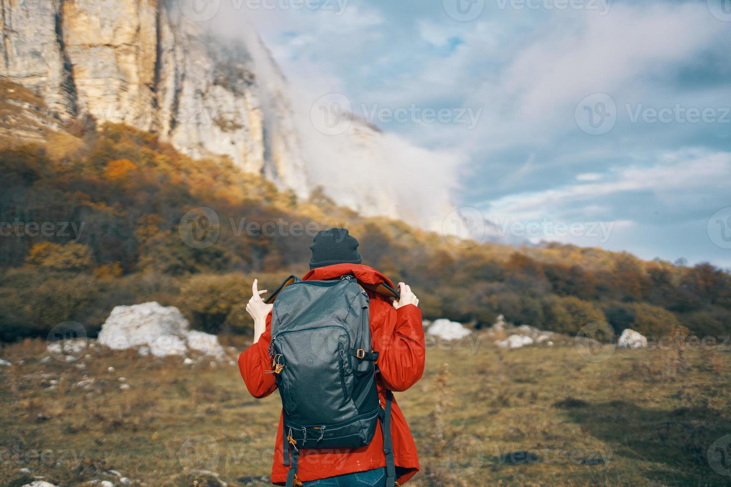 voyageur avec sac à dos dans l'automne dans le montagnes bleu ciel des nuages haute rochers paysage photo