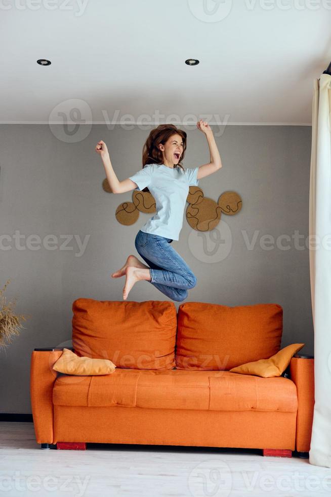 de bonne humeur femme sauter sur le canapé à Accueil divertissement photo