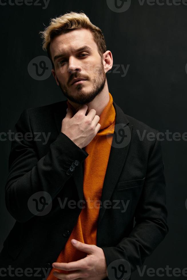 homme dans Orange chandail et noir manteau faire des gestes avec mains tondu vue photo