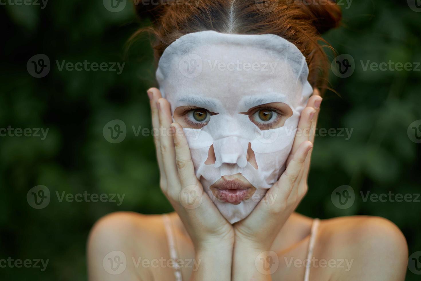 portrait de une fille cosmétique masque mains près le visage et yeux large ouvert nu épaules photo