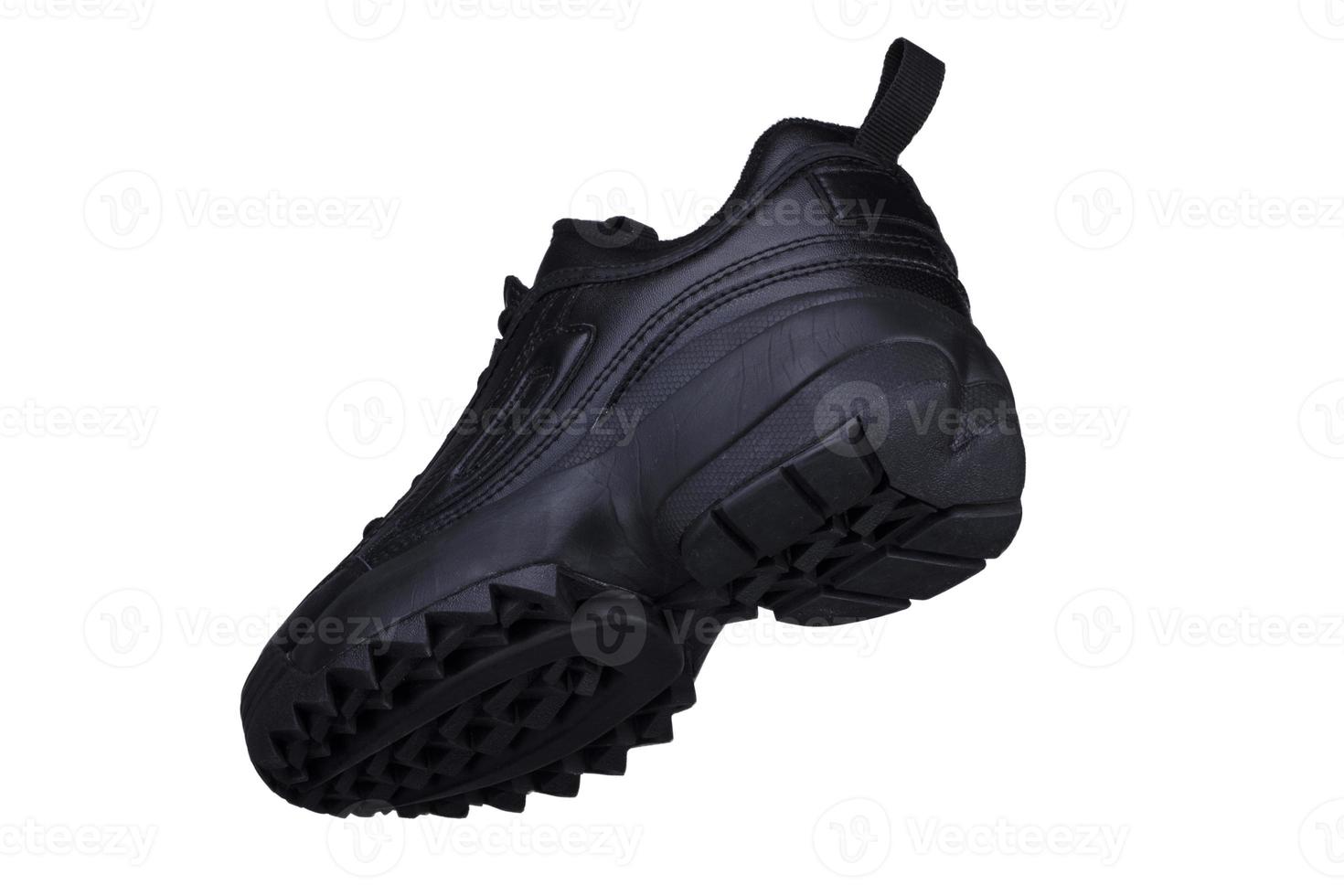 un noir baskets sur une blanc Contexte. sport chaussures. photo