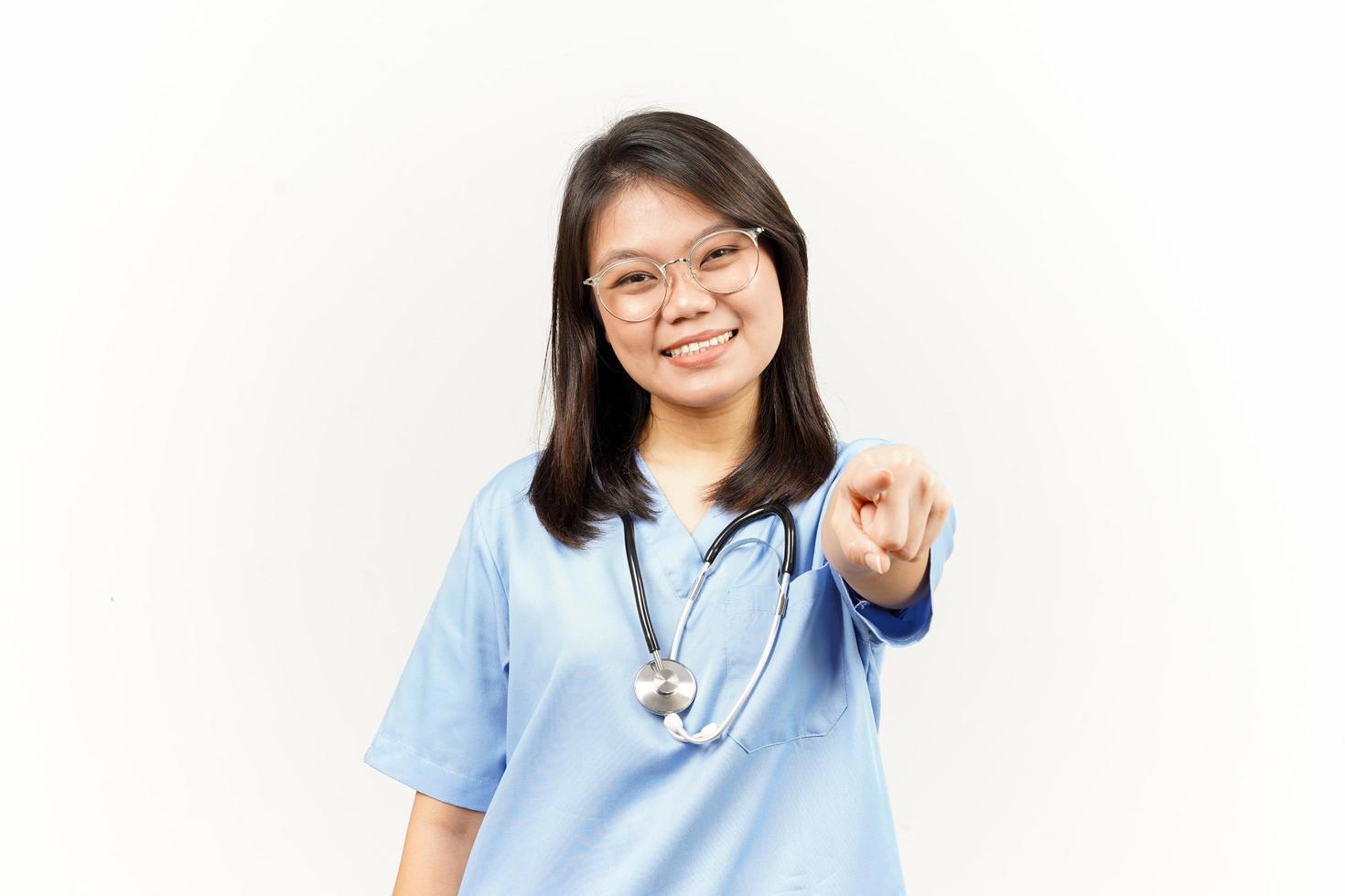 souriant et montrer du doigt à toi, vouloir vous geste de asiatique Jeune médecin isolé sur blanc Contexte photo