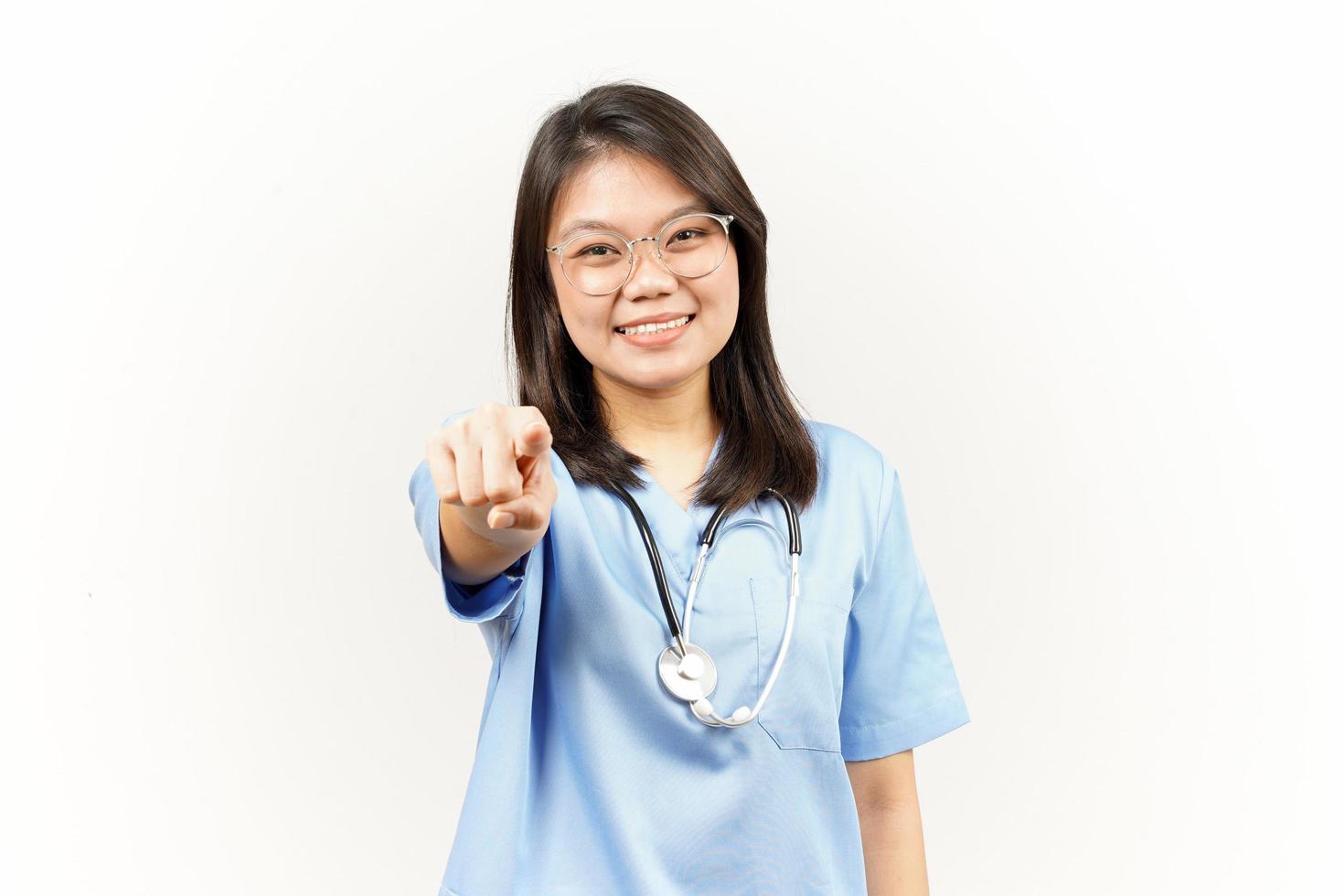 souriant et montrer du doigt à toi, vouloir vous geste de asiatique Jeune médecin isolé sur blanc Contexte photo