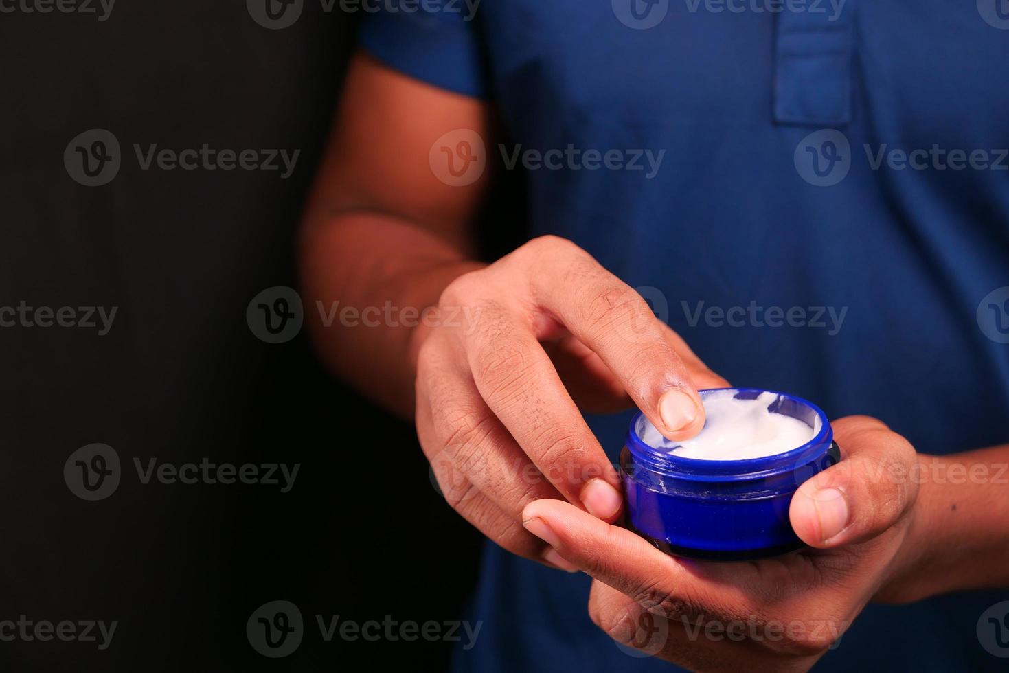 homme, appliquer la crème de beauté sur la peau photo