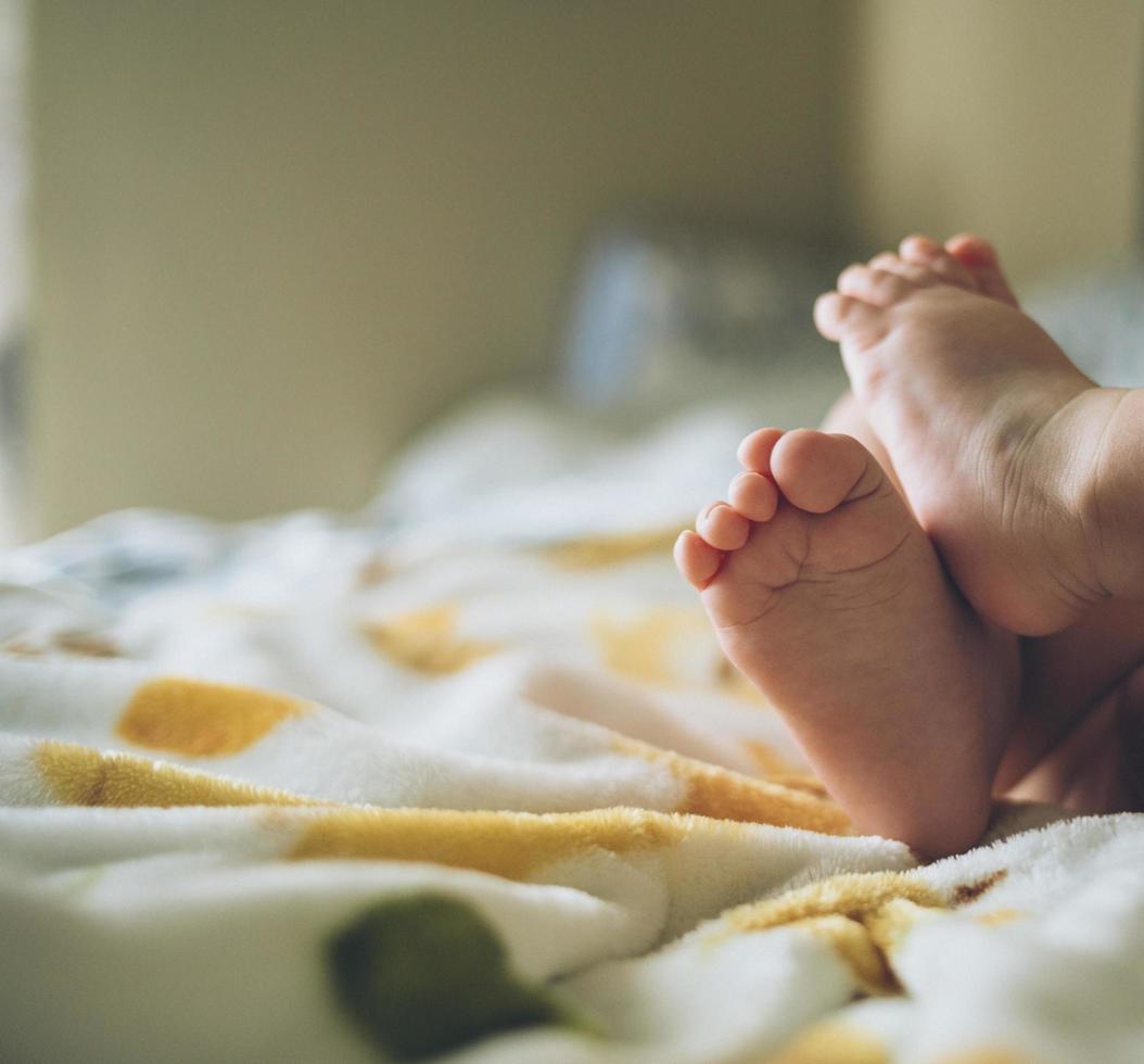 les pieds de l'enfant sur les draps photo