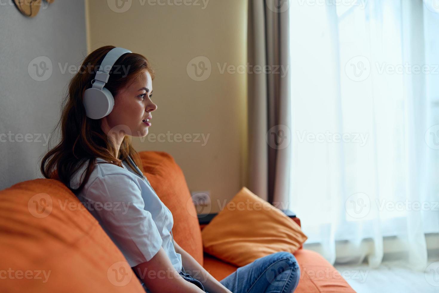 portrait de une femme casque de musique à Accueil sur le canapé divertissement mode de vie photo