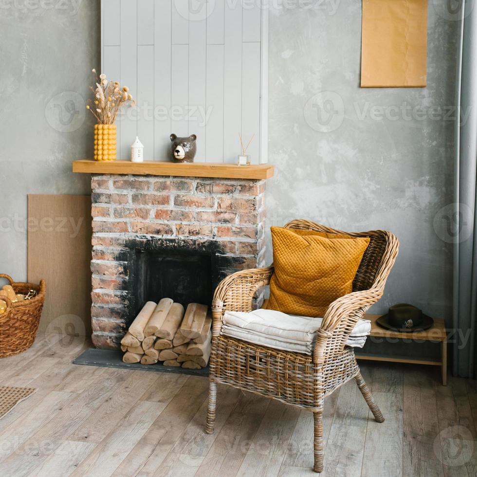 le intérieur de le vivant pièce dans une pays maison. confortable cheminée et osier chaise photo