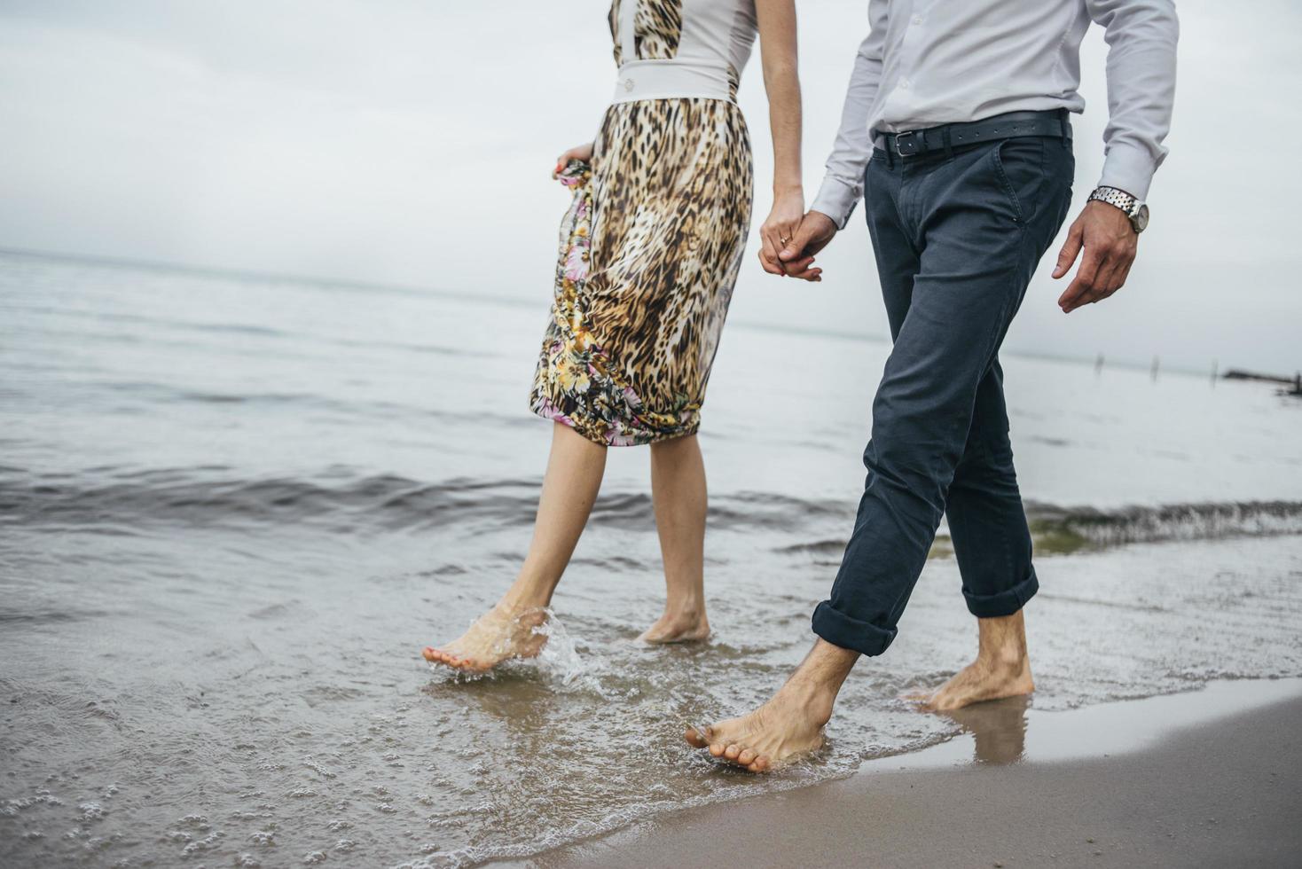 couple marchant pieds nus sur une plage photo