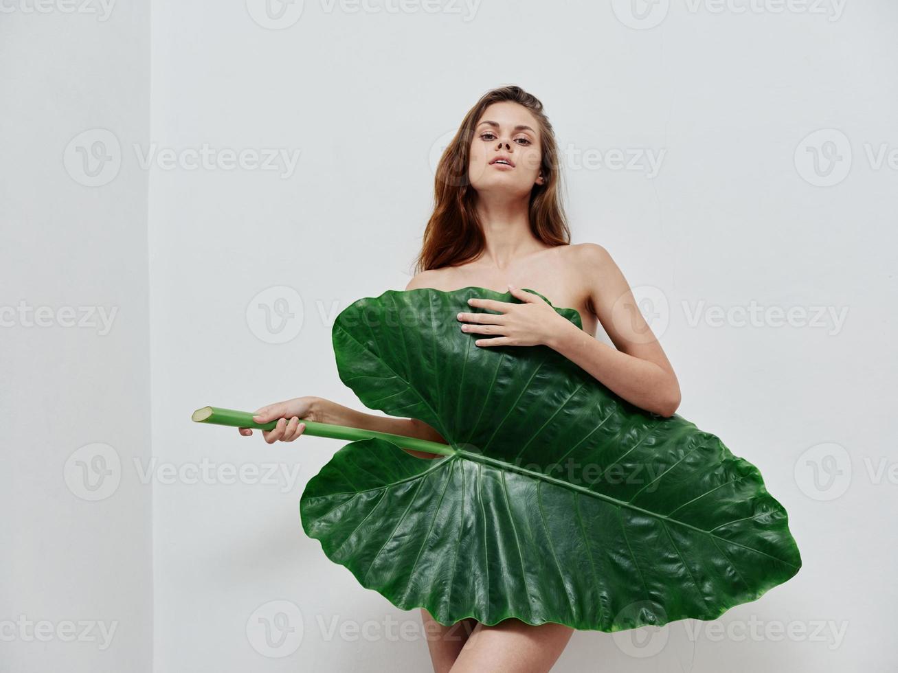 jolie femme avec nu corps couvert avec paume feuille exotique luxe photo