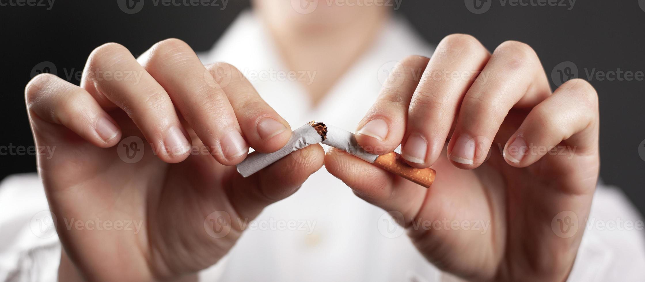 arrêter de fumer concept avec une cigarette cassée entre les mains d'un médecin photo