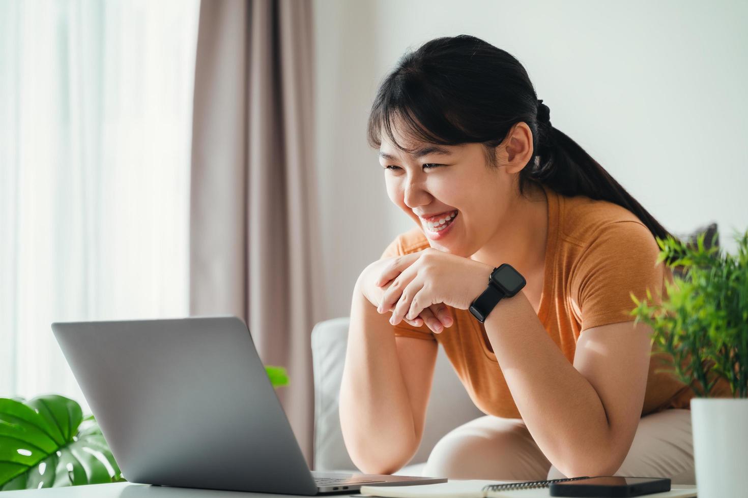 content femme en utilisant portable à Accueil Bureau ou lieu de travail. photo