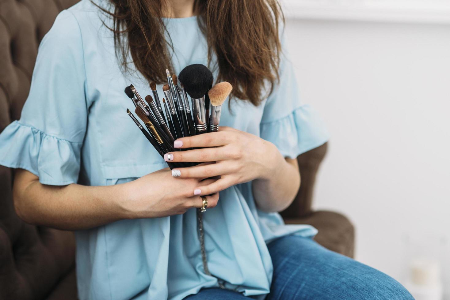 femme tenant des pinceaux de maquillage photo