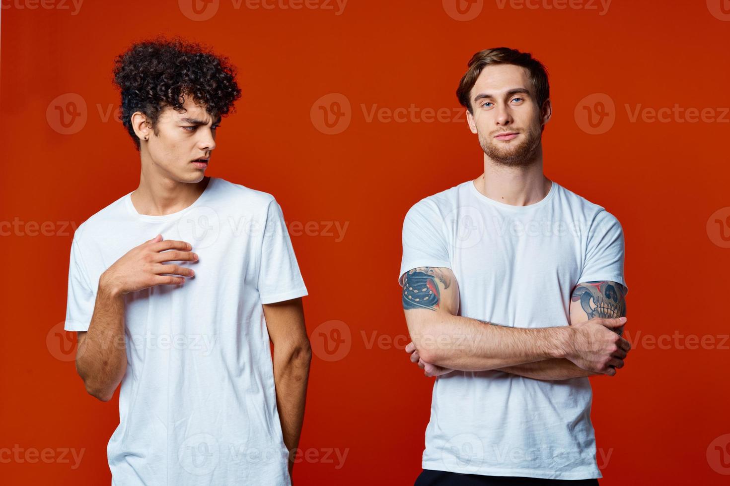 deux Hommes dans blanc t-shirts sur une rouge Contexte relation amicale photo