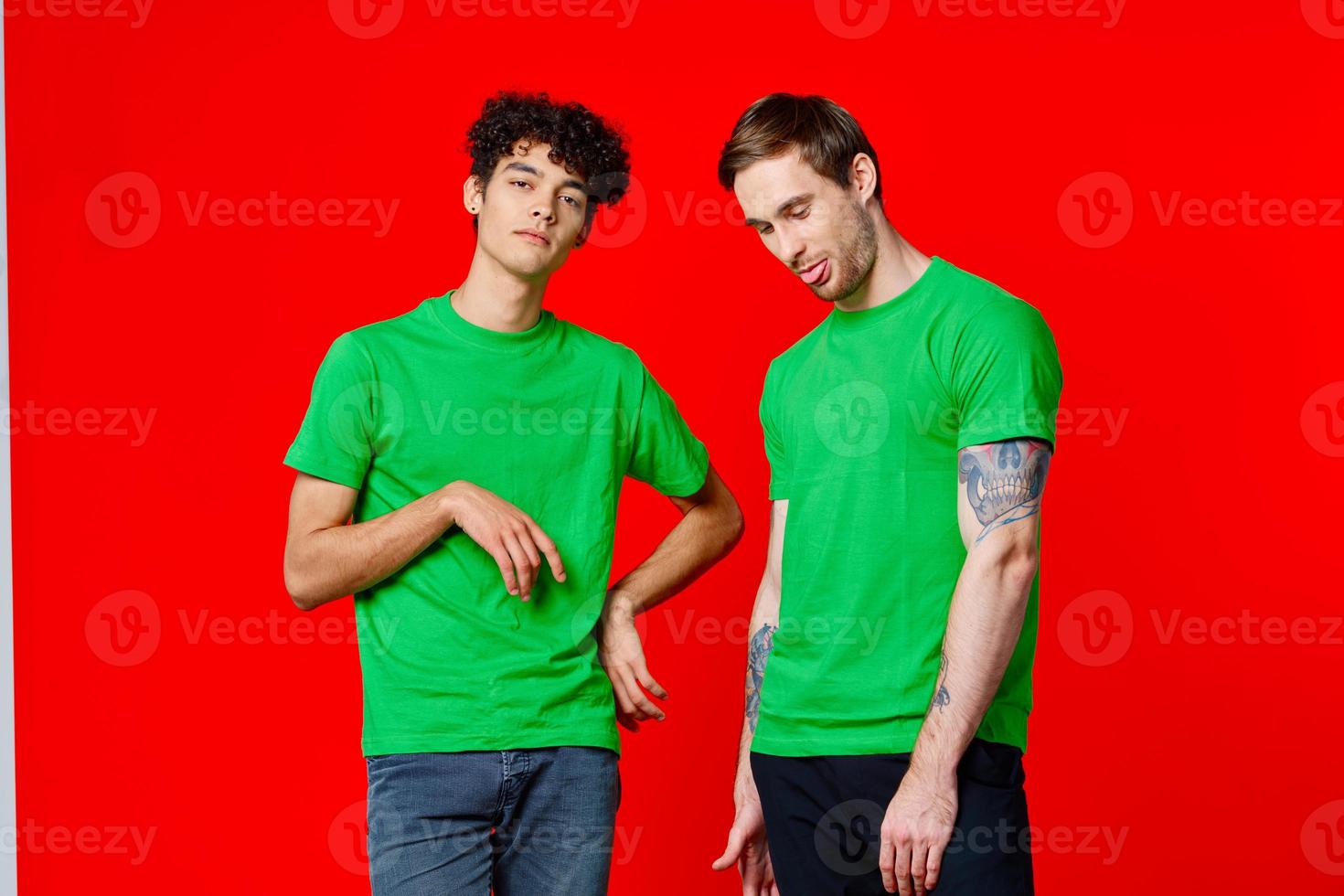 deux copains dans vert t-shirts sont permanent suivant à étain avec leur mains émotions photo