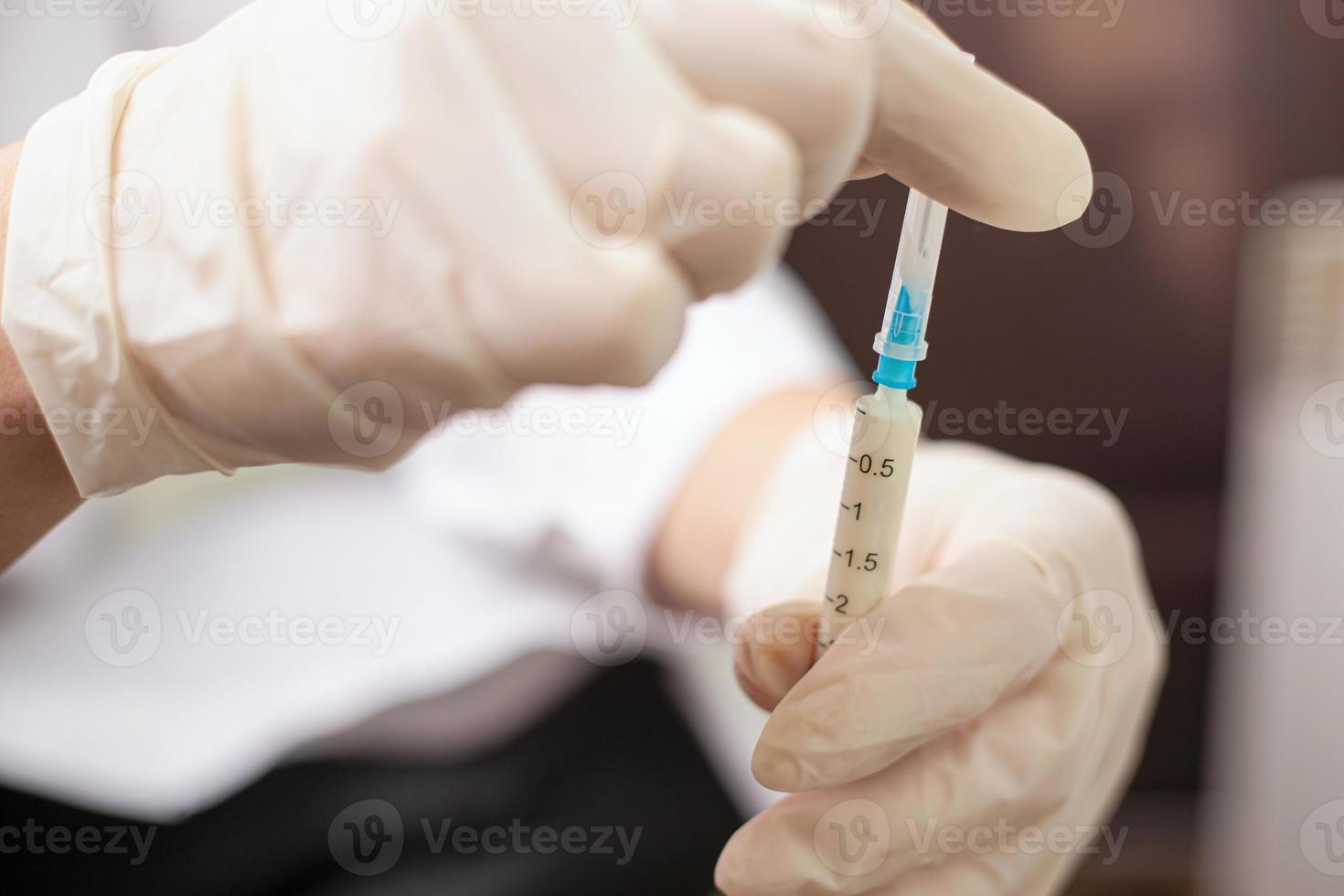 médecin tient une seringue avec un vaccin photo