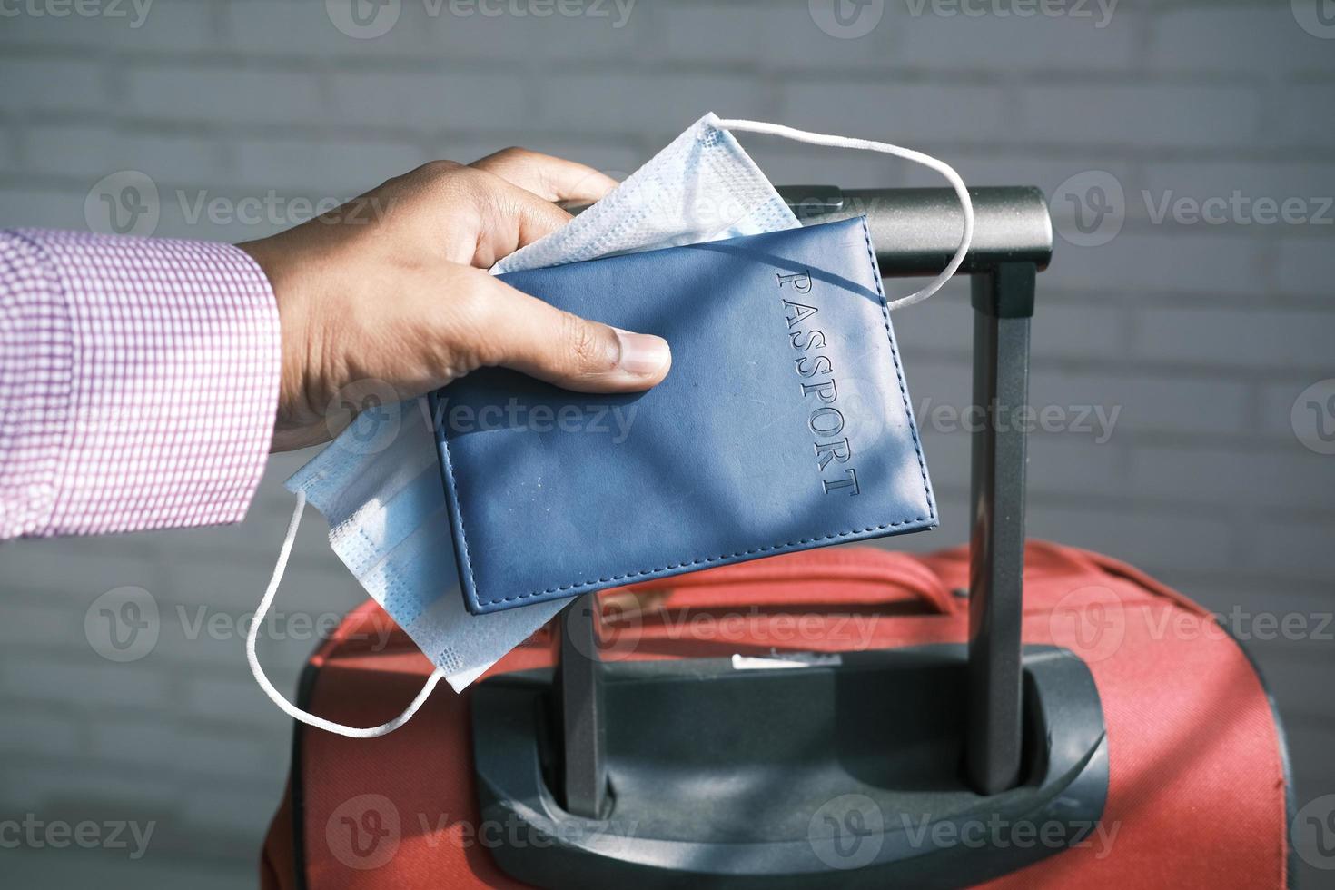 tenant le passeport en main avec valise photo