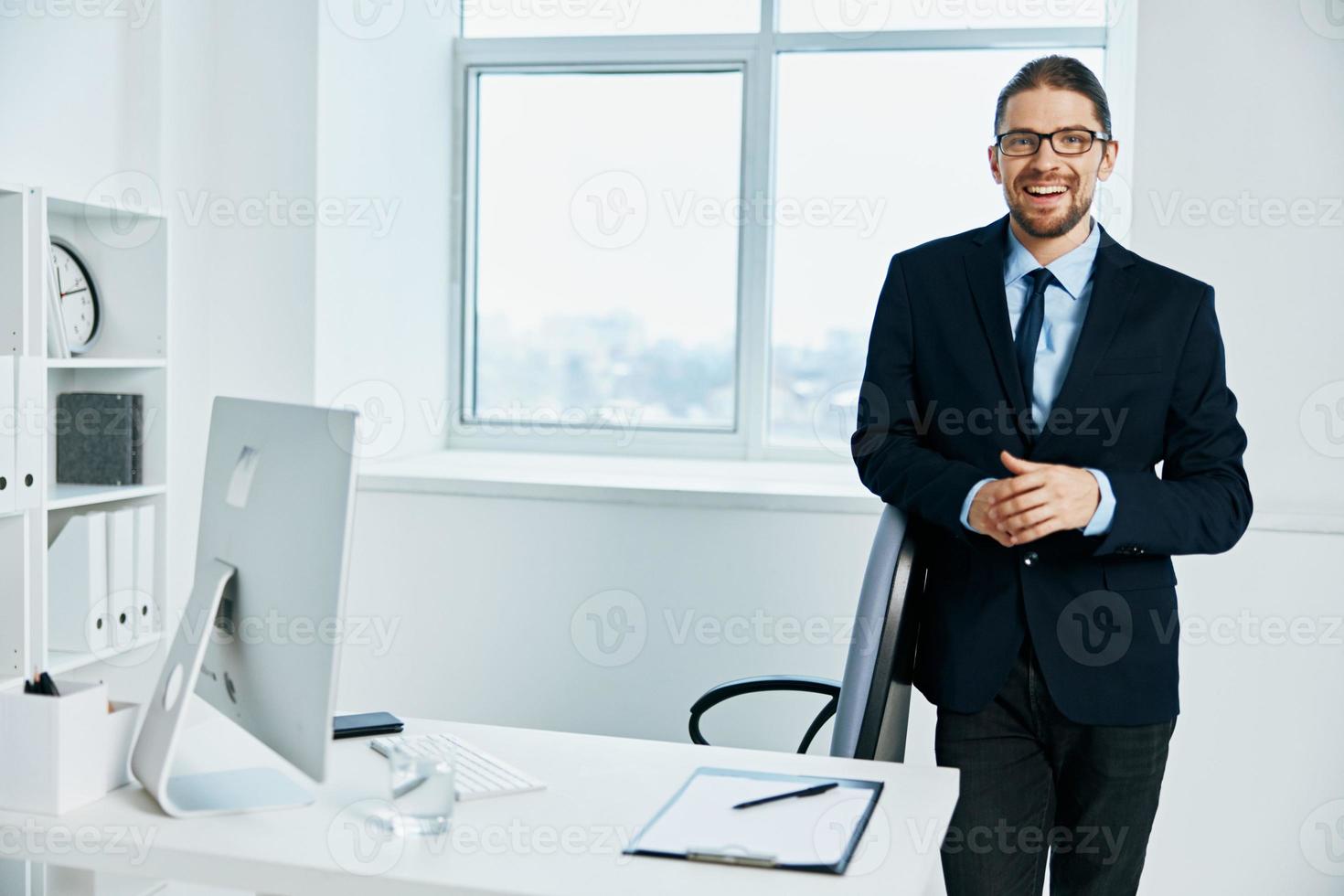 le homme dans une costume près le bureau travail processus ordinateur photo