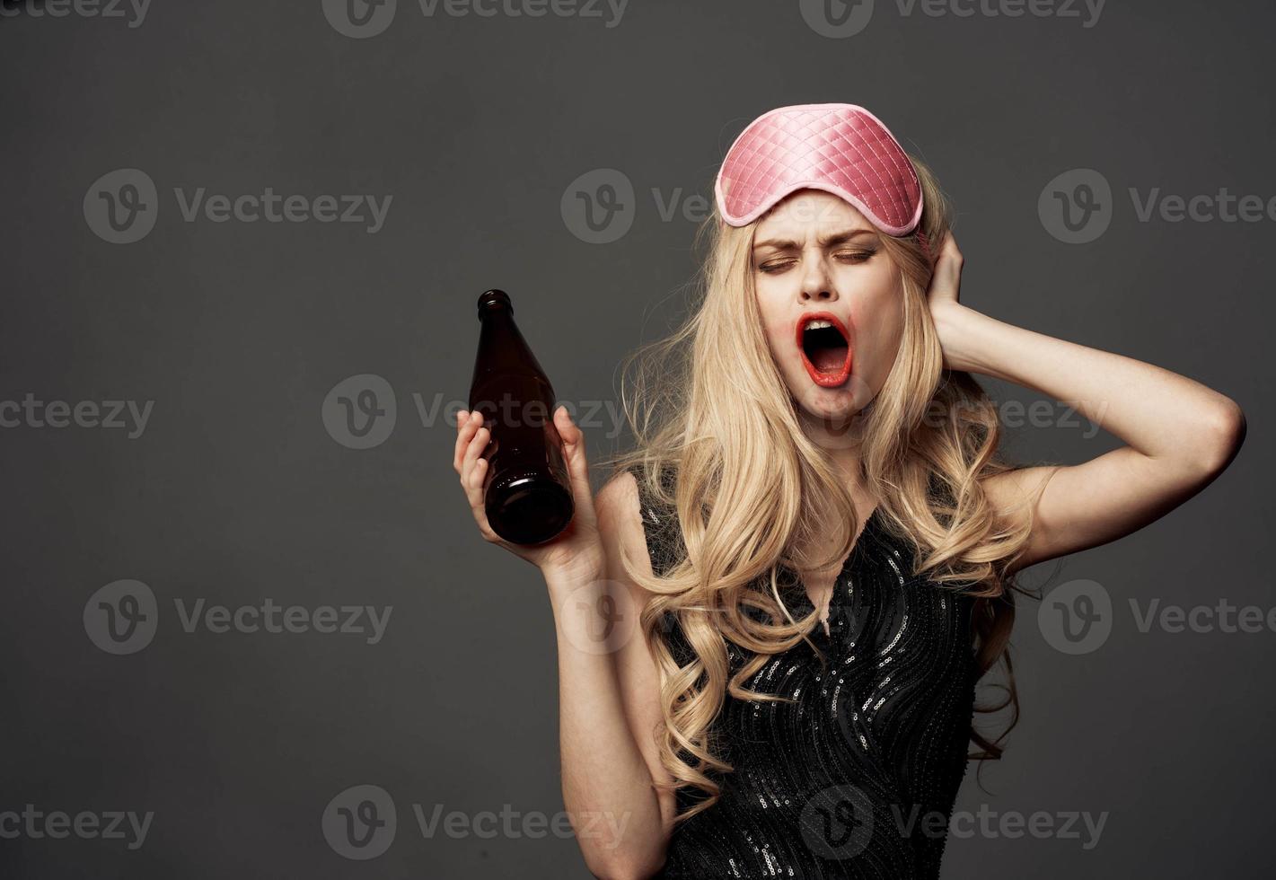 femmes avec une rose sommeil masque détient une bouteille de Bière dans sa main photo