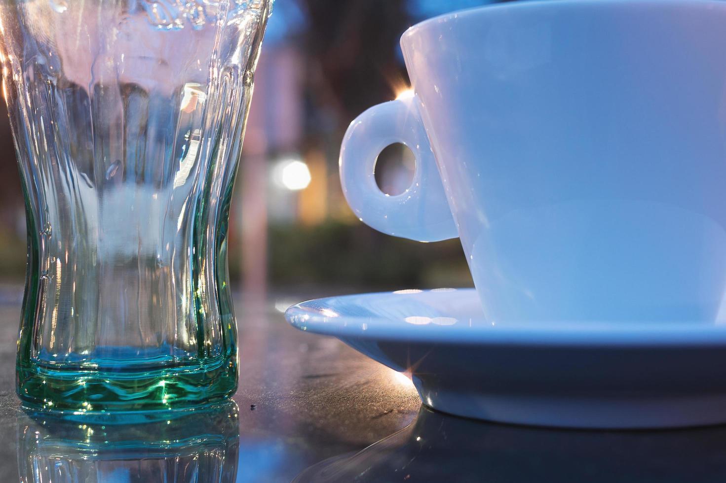 Délicieuse tasse à café et tasse en verre isolé sur fond marron photo