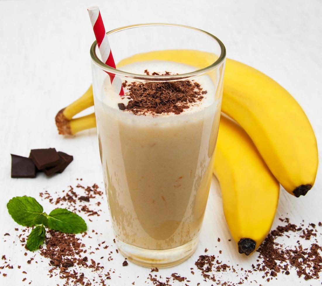 Smoothie à la banane avec du chocolat sur un vieux fond en bois blanc photo