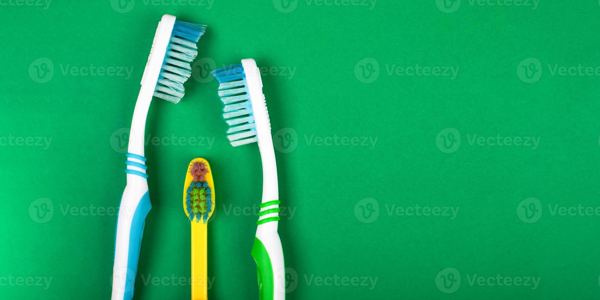 famille de brosses à dents sur fond vert photo