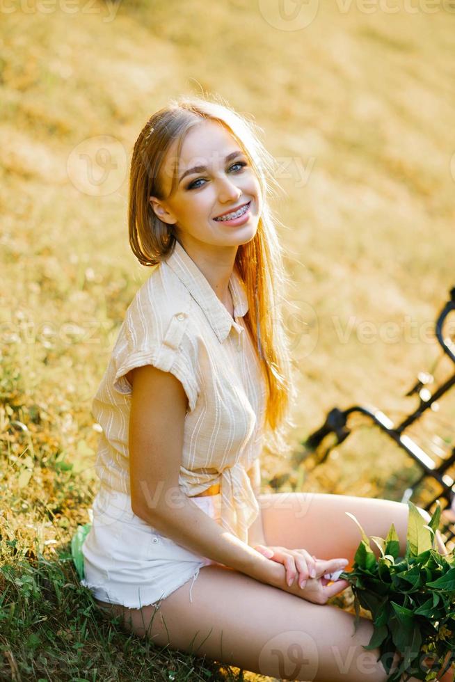 portrait de une magnifique souriant fille dans une champ dans le réglage Soleil dans été photo