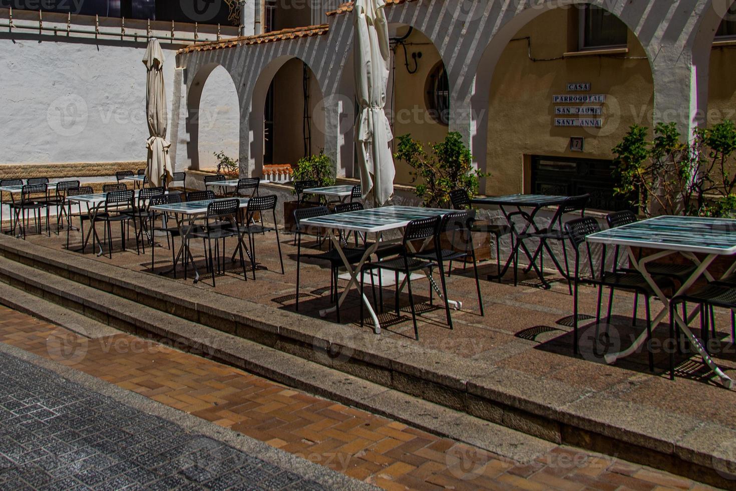 l Urbain paysage de une Espagnol rue dans benidorm avec une café et les tables sur le trottoir sans pour autant gens photo