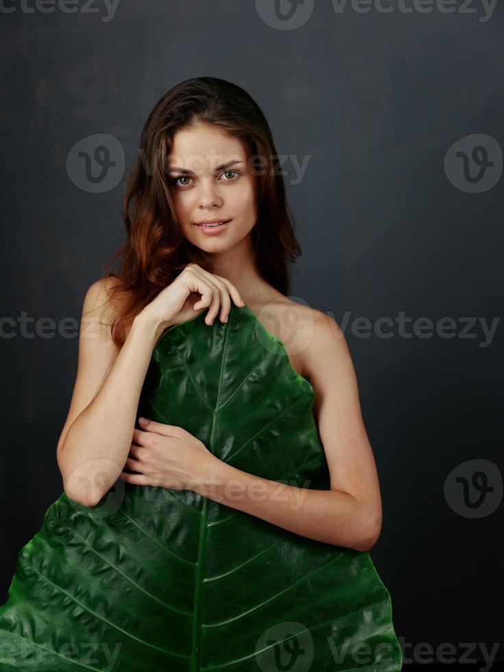 attrayant femme cache derrière paume feuille tropiques nu corps photo