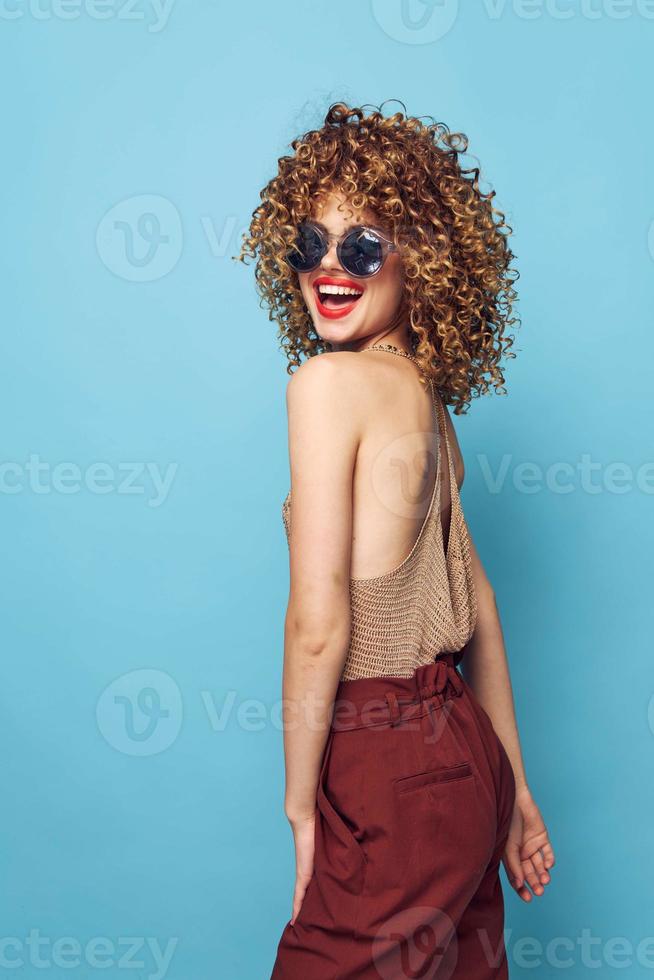 jolie femme mode sourire frisé cheveux rouge lèvres des lunettes de soleil photo