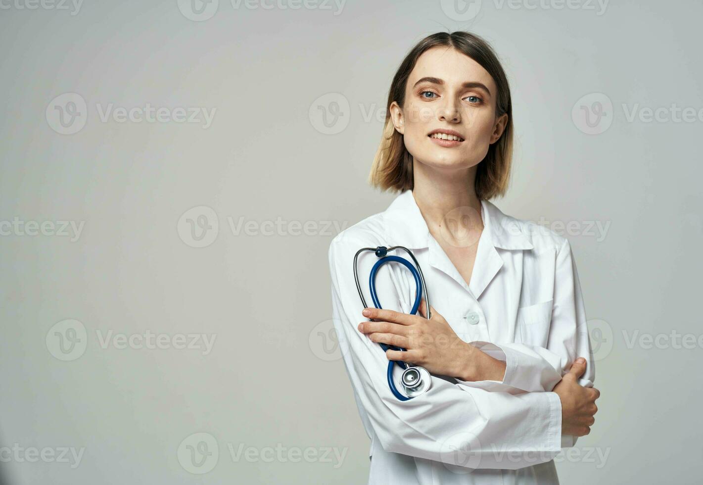 une professionnel médecin dans une médical robe détient une stéthoscope dans le sien main photo