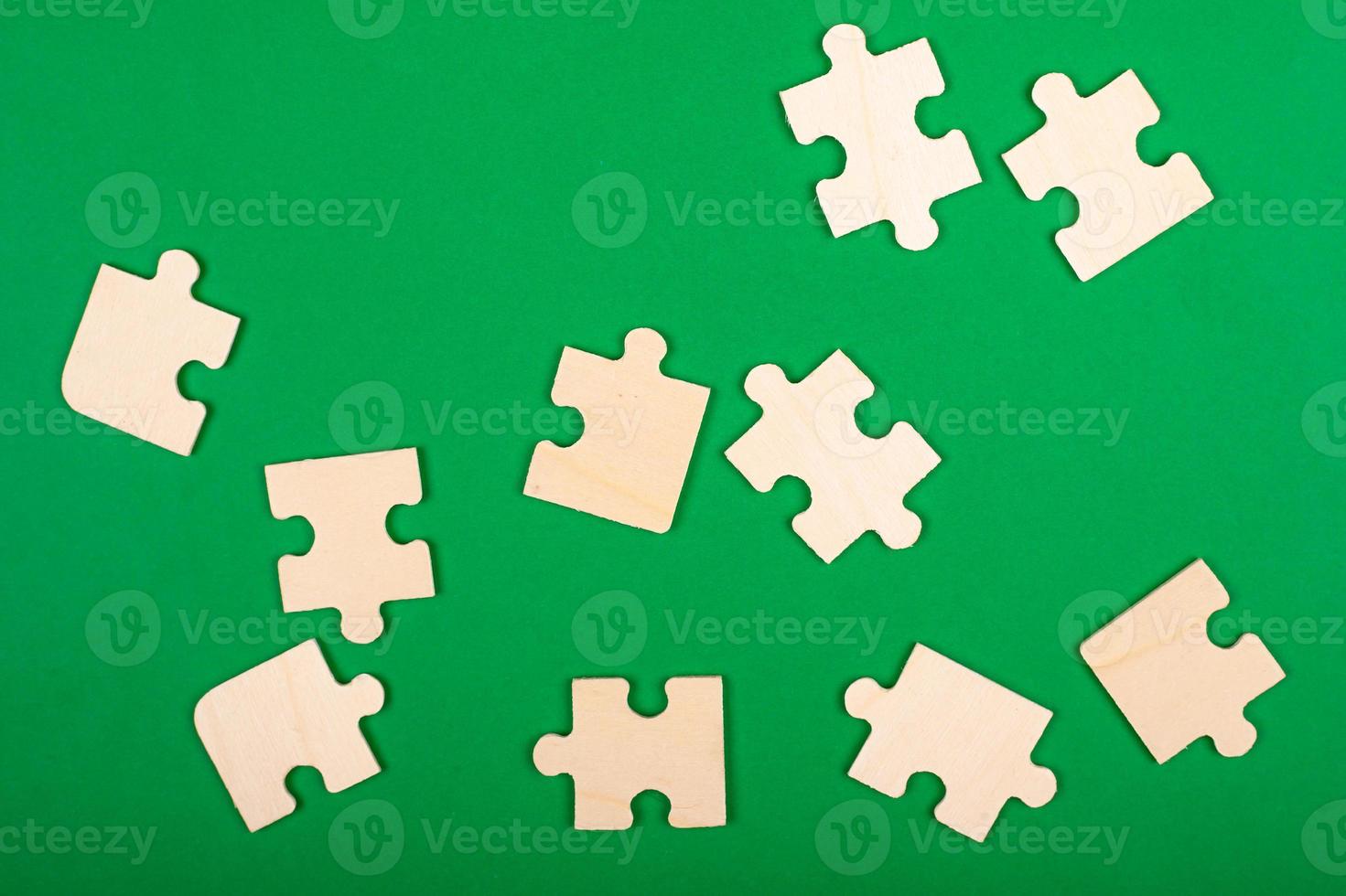 pièces de puzzle éparpillées sur un fond vert photo
