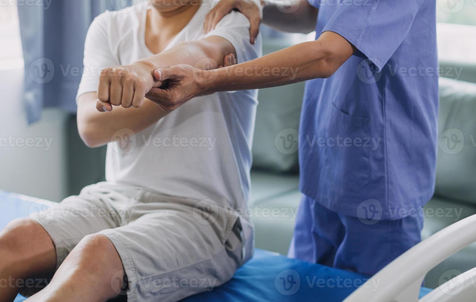 médecin ou physiothérapeute travail examiner traiter blessé bras de athlète Masculin patient, élongation et exercer, Faire le réhabilitation thérapie douleur dans clinique. photo