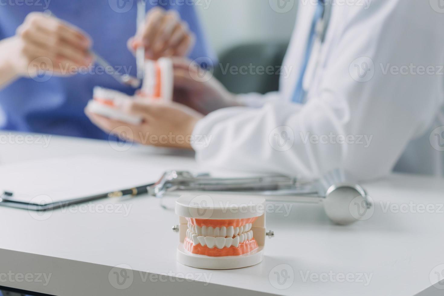 les dentistes discutent des problèmes dentaires lors du rapport de l'image radiographique sur l'écran de l'ordinateur portable aux patients. photo