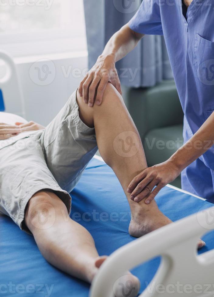 médecin ou physiothérapeute travail examiner traiter blessé bras de athlète Masculin patient, élongation et exercer, Faire le réhabilitation thérapie douleur dans clinique. photo