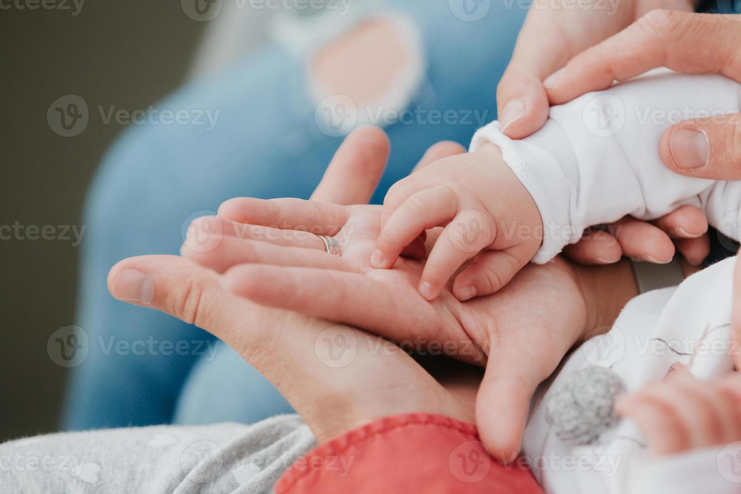 maman et papa tiennent la main de bébé. poignée pour enfants photo