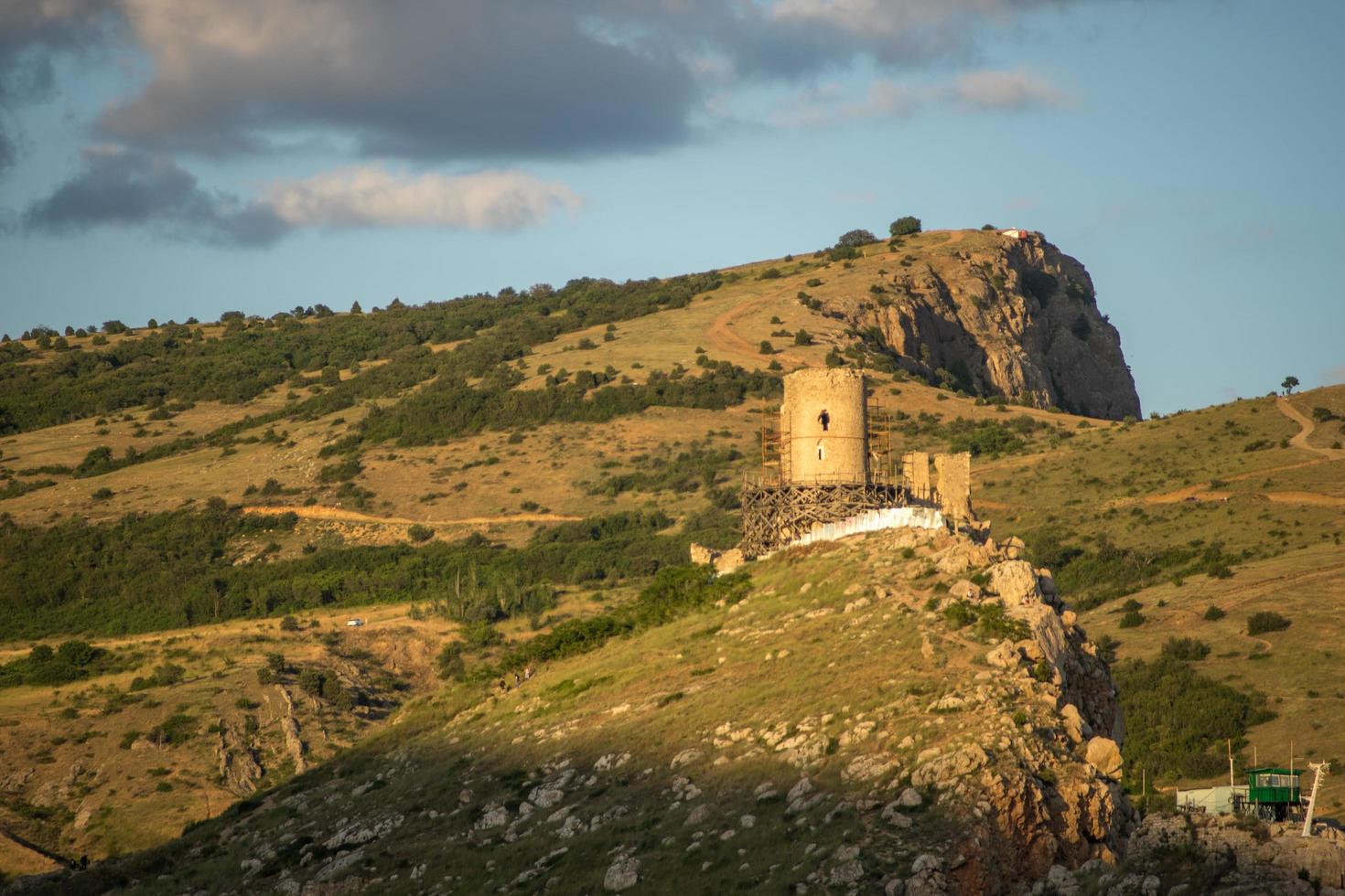 Vue de la forteresse génoise sur le flanc d'une montagne avec un ciel bleu nuageux en Crimée photo