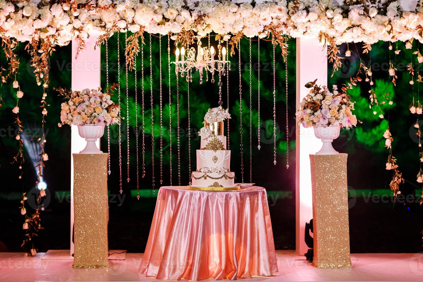 décorations de mariage. table avec un gâteau de mariage, des bougies, de la lumière et des fleurs. photo